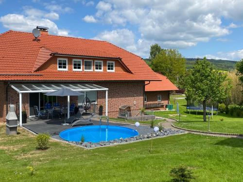 a house with a swimming pool in the yard at Ferienwohnung Naturblick in Schönhagen