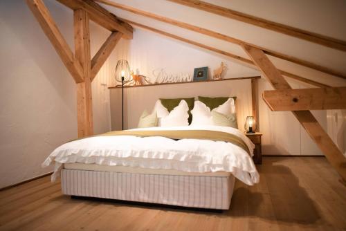 a bedroom with a white bed in a attic at Gipfelkönig in Bayrischzell