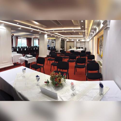 a large room with tables and chairs in a room at Theranda Hotel in Prizren