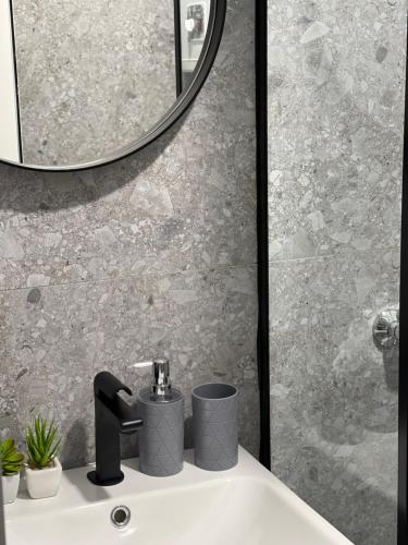 un bagno con lavandino e specchio di Vela Apartament 2 a Sarandë