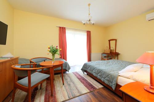a bedroom with a bed and a table and a window at Balazs Villa in Balatonfüred