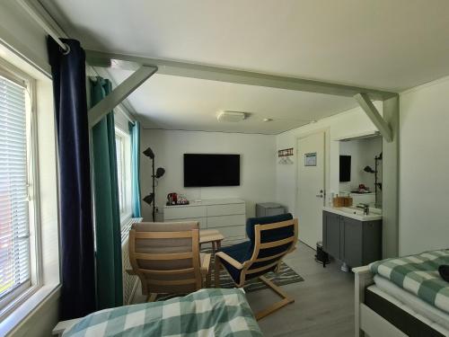 マルカリュードにあるDen Sovande Älgenの椅子2脚とテーブル1台付きの部屋、ベッドルーム1室が備わる客室です。