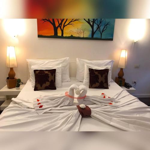 a white bed with a stuffed animal on it at Theranda Hotel in Prizren