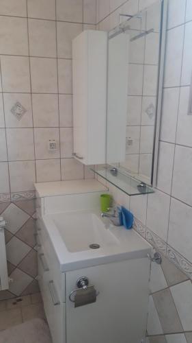 a bathroom with a white sink and a mirror at Apartman Oasis 2 Ilidza in Sarajevo