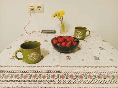 una mesa con dos tazas de café y un bol de fruta en Гостевой Дом "Bravo" на Казанской, en San Petersburgo