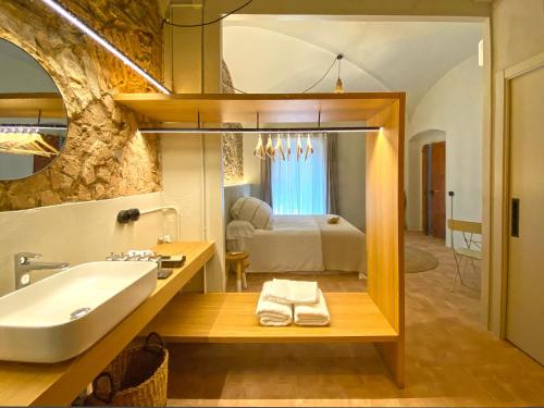 baño con bañera y lavamanos y cama en Casa Elvira, en Torroella de Montgrí