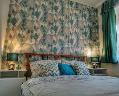 エゲルにあるFoglal-lak Apartmanのベッドルーム1室(幾何学的な壁のベッド1台付)