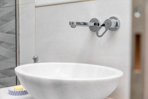 a white sink with a faucet on a wall at AZUR in Naxos Chora
