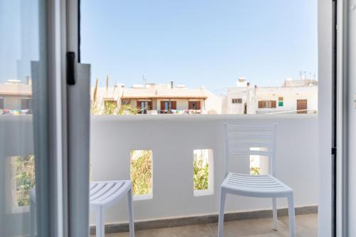 two white stools on a balcony with a window at AZUR in Naxos Chora