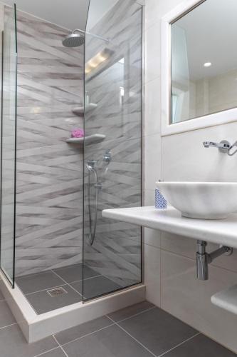 a bathroom with a glass shower and a sink at AZUR in Naxos Chora