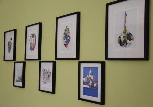 a group of framed pictures on a wall at Large Apartment near the beach and Lisbon in Costa da Caparica