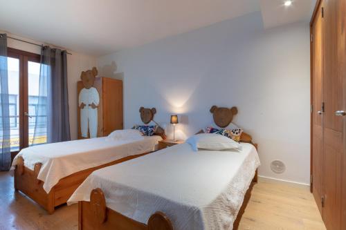 a bedroom with two beds with teddy bears on the wall at NEW! Villa Boutique Mallorca in Lloseta