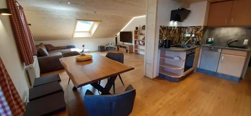 a kitchen and living room with a wooden table and a dining room at seitzDAHEIM in Bad Hindelang