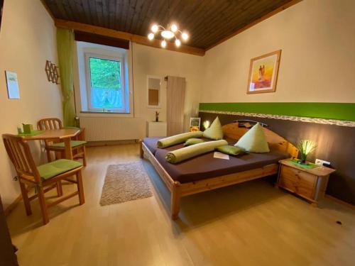 een slaapkamer met een bed, een tafel en een stoel bij Gasthof Wölger in Admont