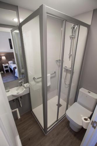 a bathroom with a shower and a toilet and a sink at Pensión San Martin in Donostia-San Sebastián