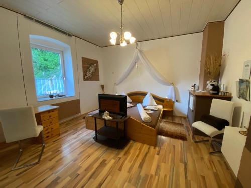 een woonkamer met een bank en een tafel met een televisie bij Gasthof Wölger in Admont