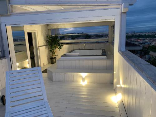 a balcony with a bed and a white chair on avisor at SuiteFrattini Private Spa Rooftop in Rome