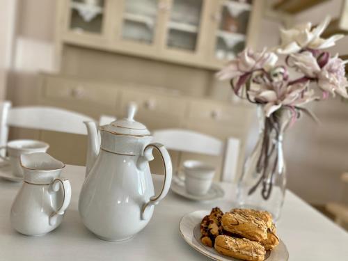 a table with a plate of cookies and a vase with flowers at Rebekka's HOUSE in Zákros