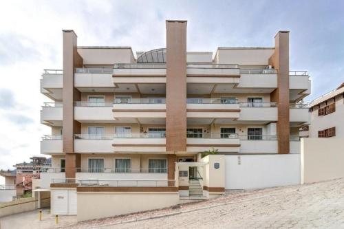 un gran edificio blanco con en Res. Praia DI Capri, en Bombinhas