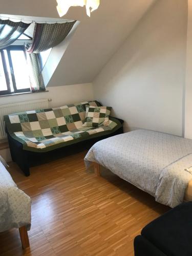 a attic room with two beds and a couch at Apartmán Slovinská 28 in Brno