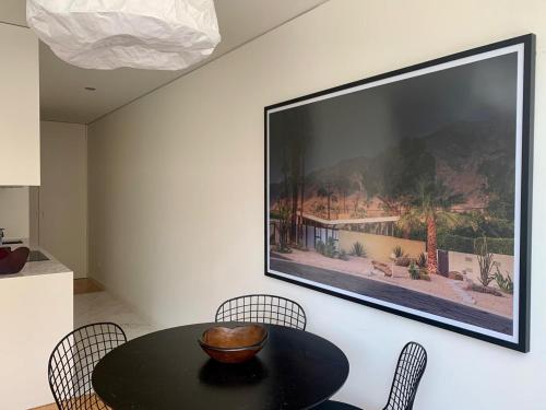 una televisione appesa a un muro con tavolo e sedie di Oporto Chic & Cozy - Santa Catarina a Porto