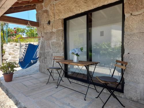 a table and chairs on a patio with a window at Casas do Arrabalde in Amarante