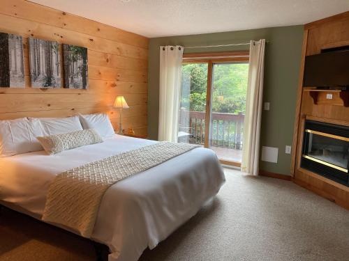 a bedroom with a large bed and a fireplace at The Snowed Inn in Killington