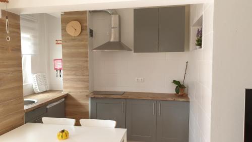 una cocina con armarios grises y una mesa blanca en Sunset Relax Porch, en Lagos