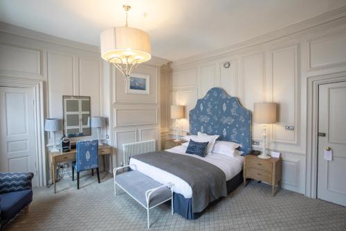 a bedroom with a bed and a chair and a desk at The George Hotel and Beach Club in Yarmouth