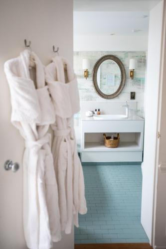 a bathroom with white towels hanging on a wall at The George Hotel and Beach Club in Yarmouth