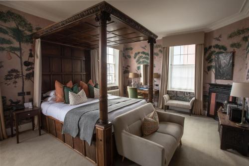 a bedroom with a canopy bed and a couch at The George Hotel and Beach Club in Yarmouth