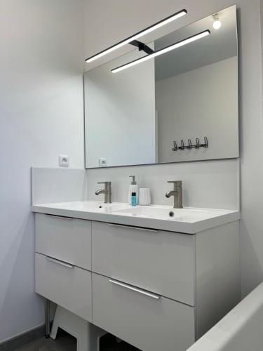 une salle de bain blanche avec un lavabo et un miroir dans l'établissement Recent house in a hamlet near the Cher, à Athée-sur-Cher