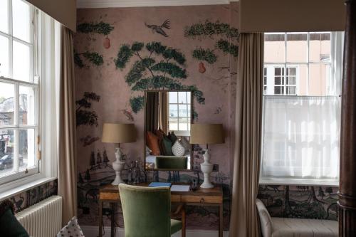 a room with a desk and a mirror on the wall at The George Hotel and Beach Club in Yarmouth