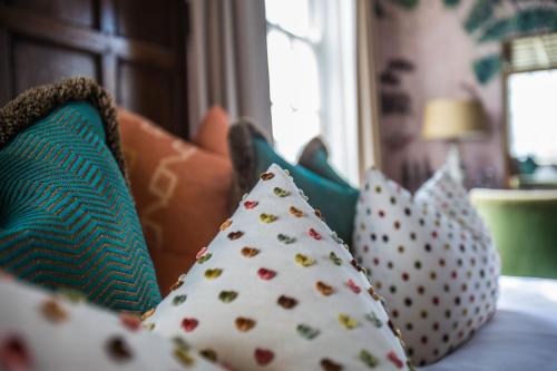 a group of pillows sitting on a bed at The George Hotel and Beach Club in Yarmouth