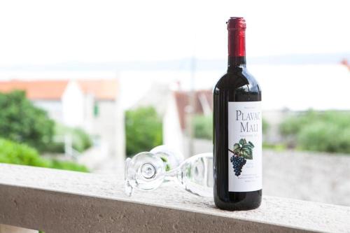 a bottle of red wine sitting on a railing at Bungalows Ivan (3757) in Bol