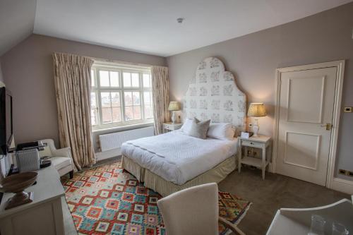 a bedroom with a bed and a large window at The George Hotel and Beach Club in Yarmouth
