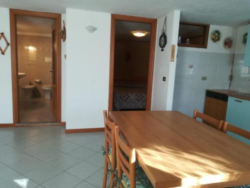 a kitchen with a wooden table and a bathroom at Appartamento con vista chez Mary in Roisan
