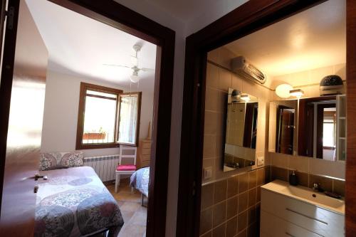 a bedroom with a bed and a sink and a mirror at El Rincón de Doina in Alquézar