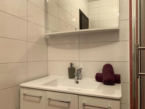 a white bathroom with a sink and a mirror at Villa Riki in Živogošće
