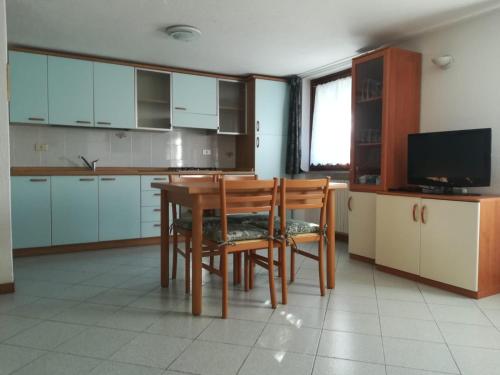 a kitchen with a table and chairs and a television at Appartamento con vista chez Mary in Roisan