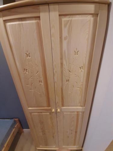 a wooden cabinet with two doors in a room at Domek u Andrzeja 2 in Ciche