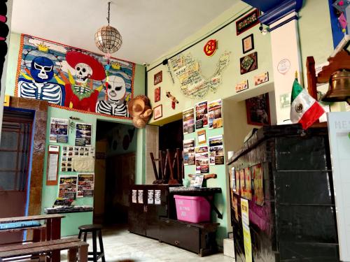 a room with posters on the walls and a room with a table at The Roof Backpackers in Guadalajara