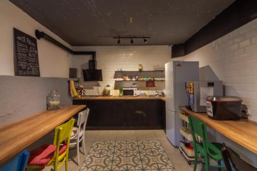 uma cozinha com um balcão com cadeiras e um frigorífico em Old Town Hostel Ohrid em Ohrid