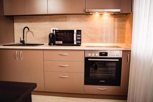 eine Küche mit Mikrowelle und Herd in der Unterkunft Apartment Gabriela's Home in Oradea