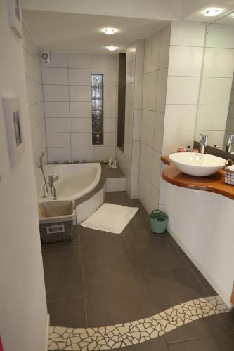 une salle de bain avec une baignoire et un lavabo dans l'établissement Au Petit Paradis, à Ammerschwihr