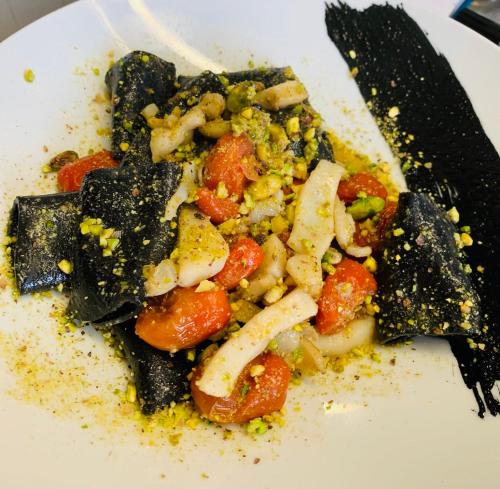 a plate of food with vegetables and a fork at Relais Real Collegio in Noli