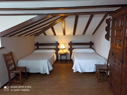 two beds in a room with a attic at Pension Castio in Santillana del Mar