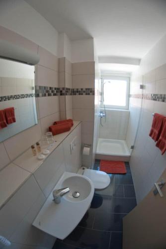 a white bathroom with a toilet and a sink at Boardinghouse Münster - das Original in Münster