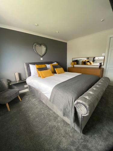 - une chambre avec un grand lit et des oreillers jaunes dans l'établissement Craster Crew Quarters, à Craster