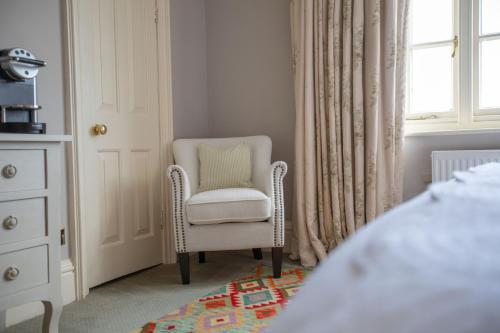 a bedroom with a chair and a window at The George Hotel and Beach Club in Yarmouth